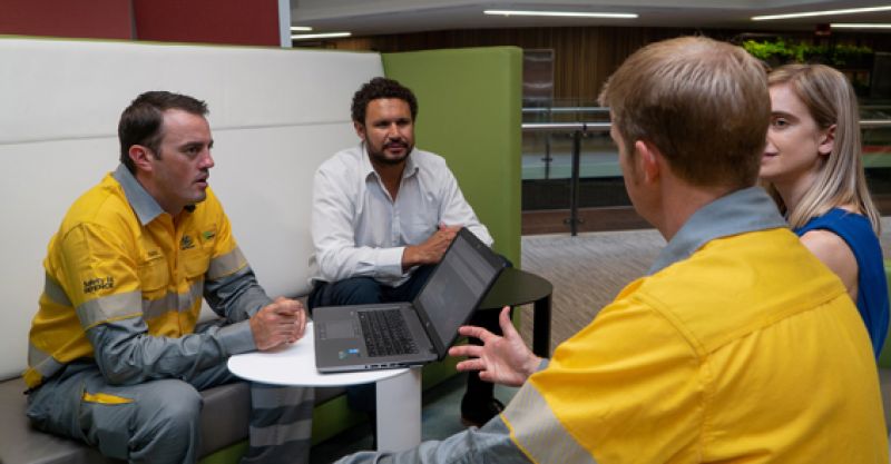 Four employees sitting at a table talking together