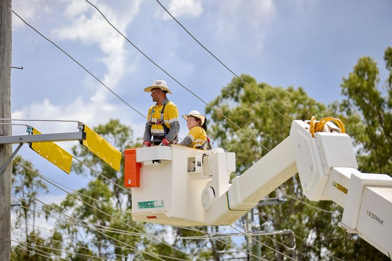 Workers near powerlines yellow blankets