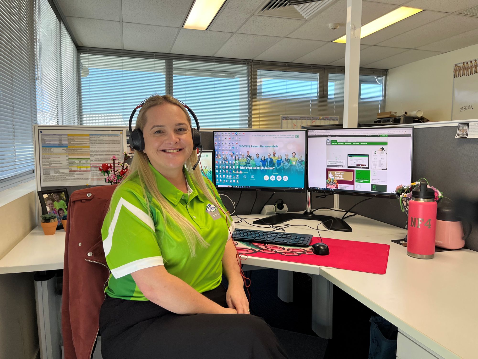 Retail worker sitting at desk with headset on and computer in background
