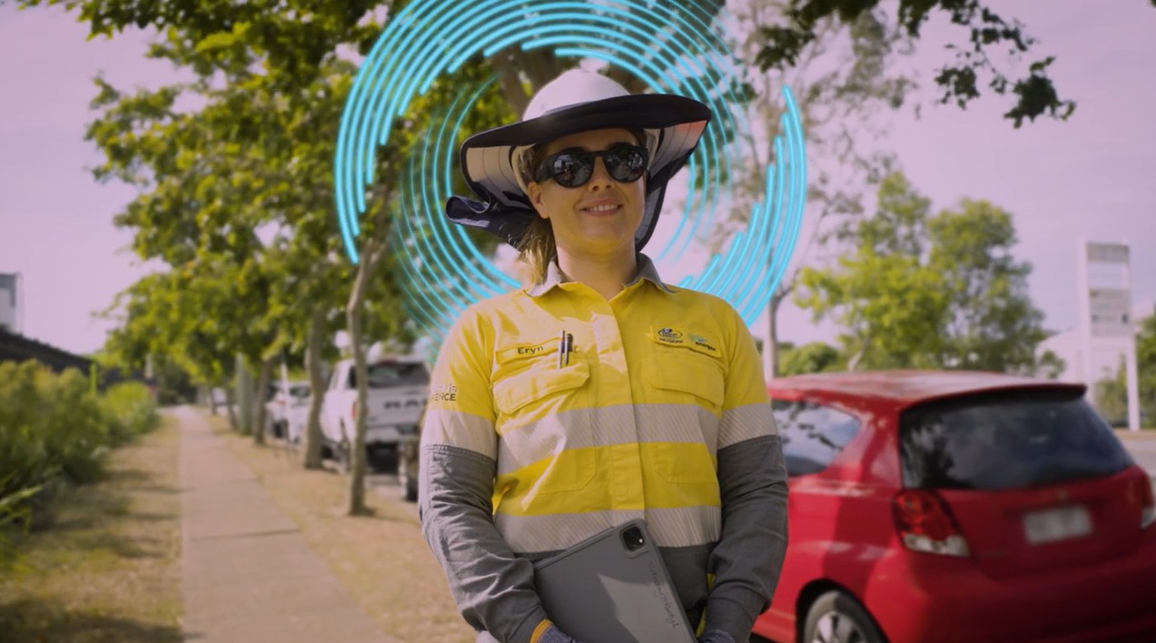 Worker standing on footpath next a car