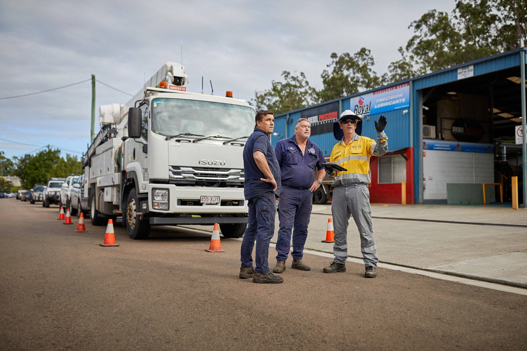 Worker and community on road in front of truck