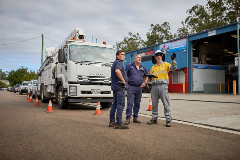 Worker and community on road in front of truck