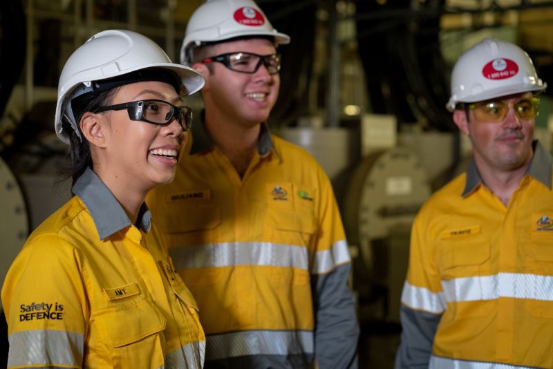 Three workers in uniform in a warehouse