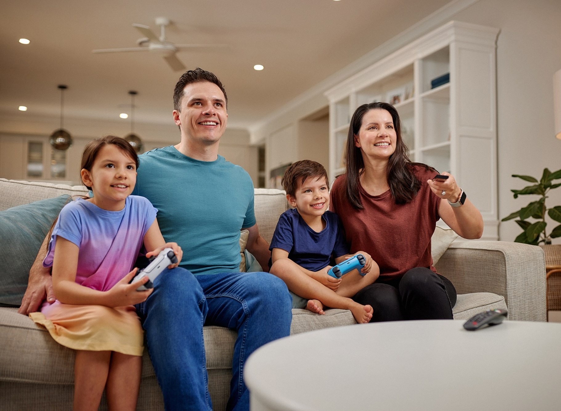 Family in a lounge room with remote controllers